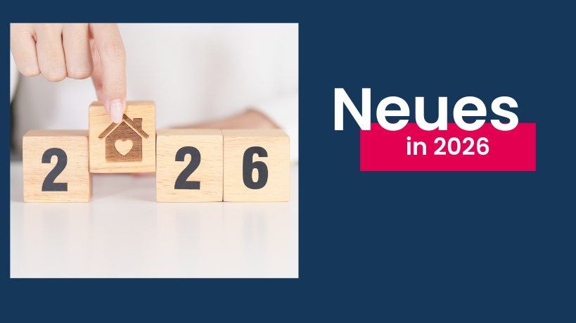 Eine Hand stellt ein Holzklötzchen mit einem eingravierten Häuschen zwischen andere Holzklötzchen, die zusammen "2026" ergeben.
