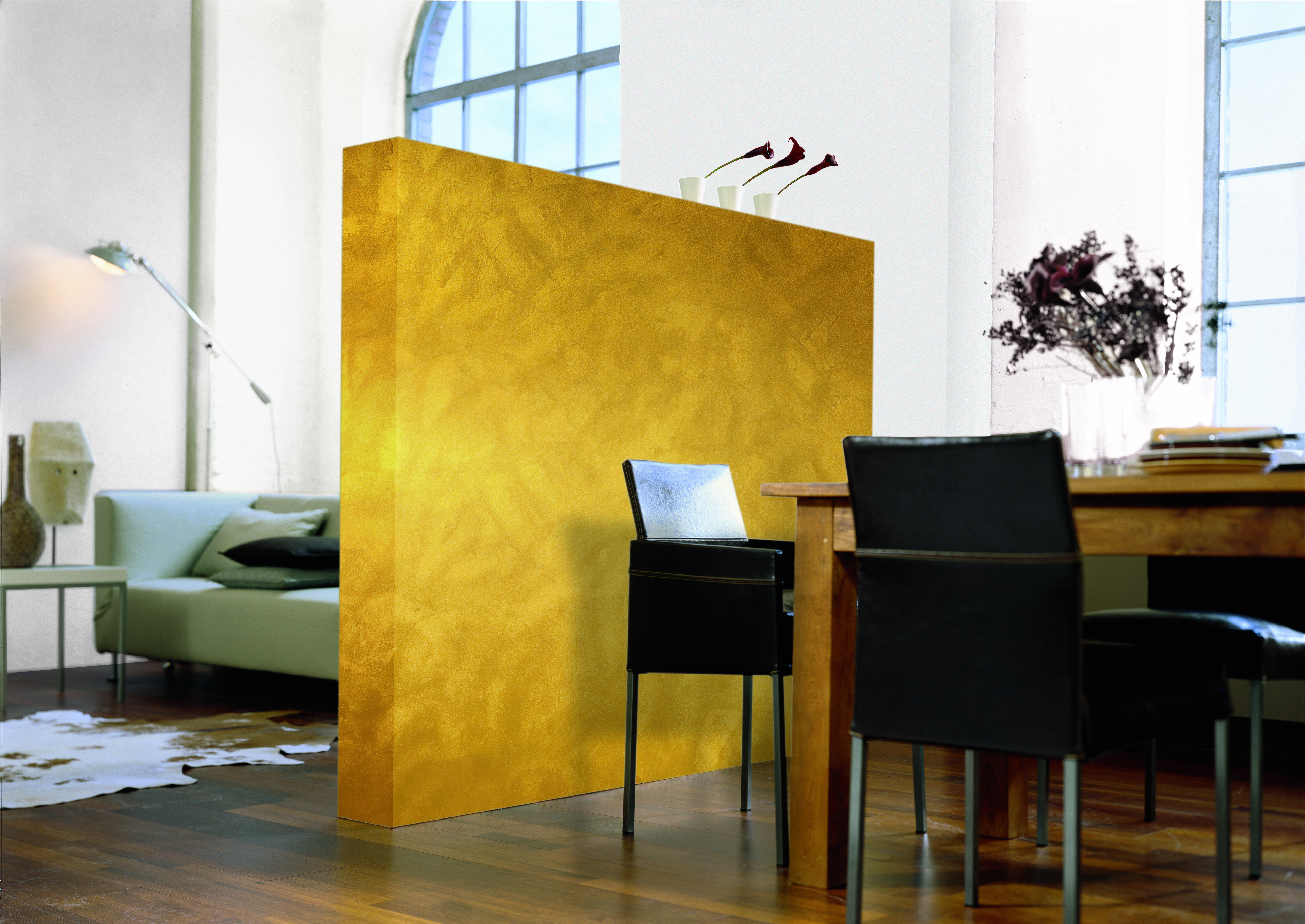 Goldfarbene Zrennwand zwischen Esszimmer und Wohnzimmer.