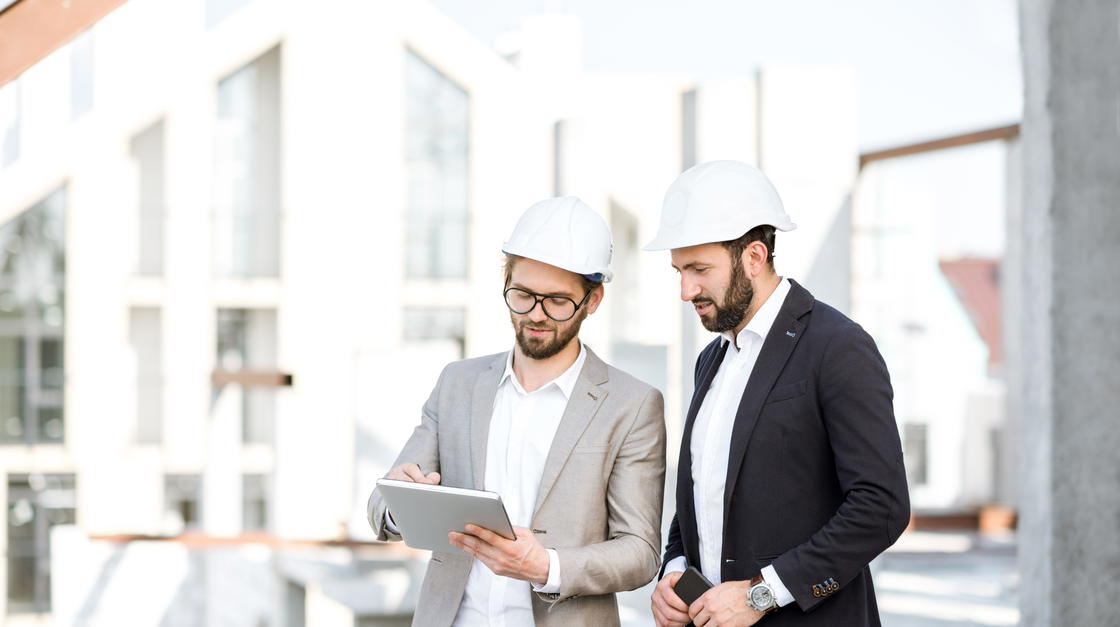 Zwei Männer auf einer Baustelle gehen eine Liste durch