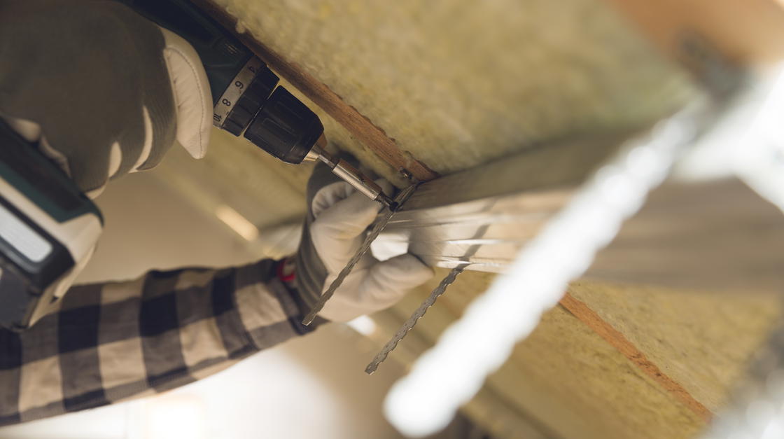 Handwerker dämmt eine Kellerdecke