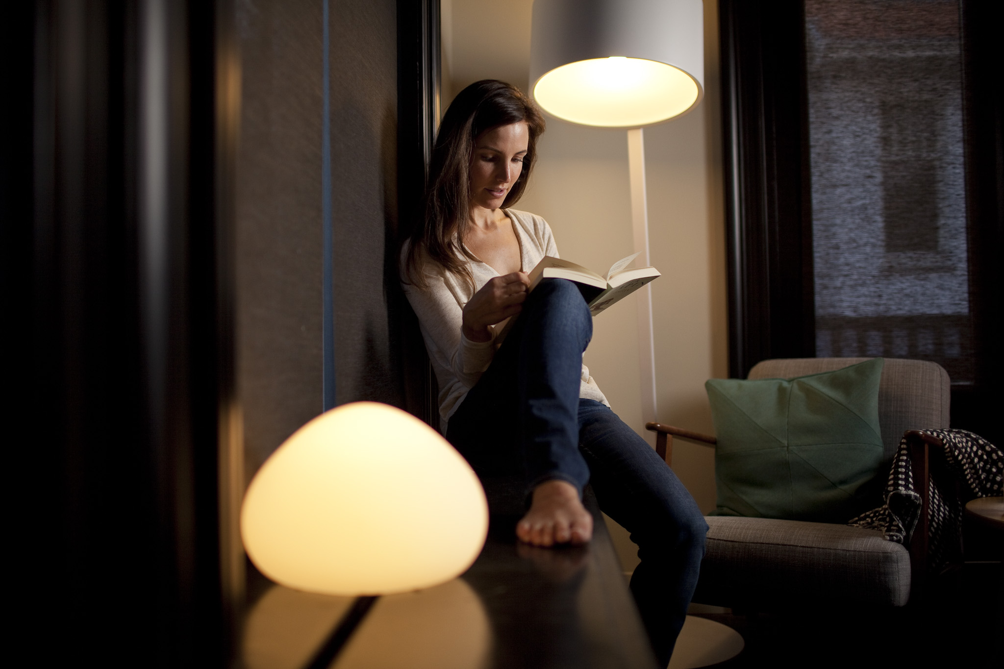 Frau liest unter Lampe