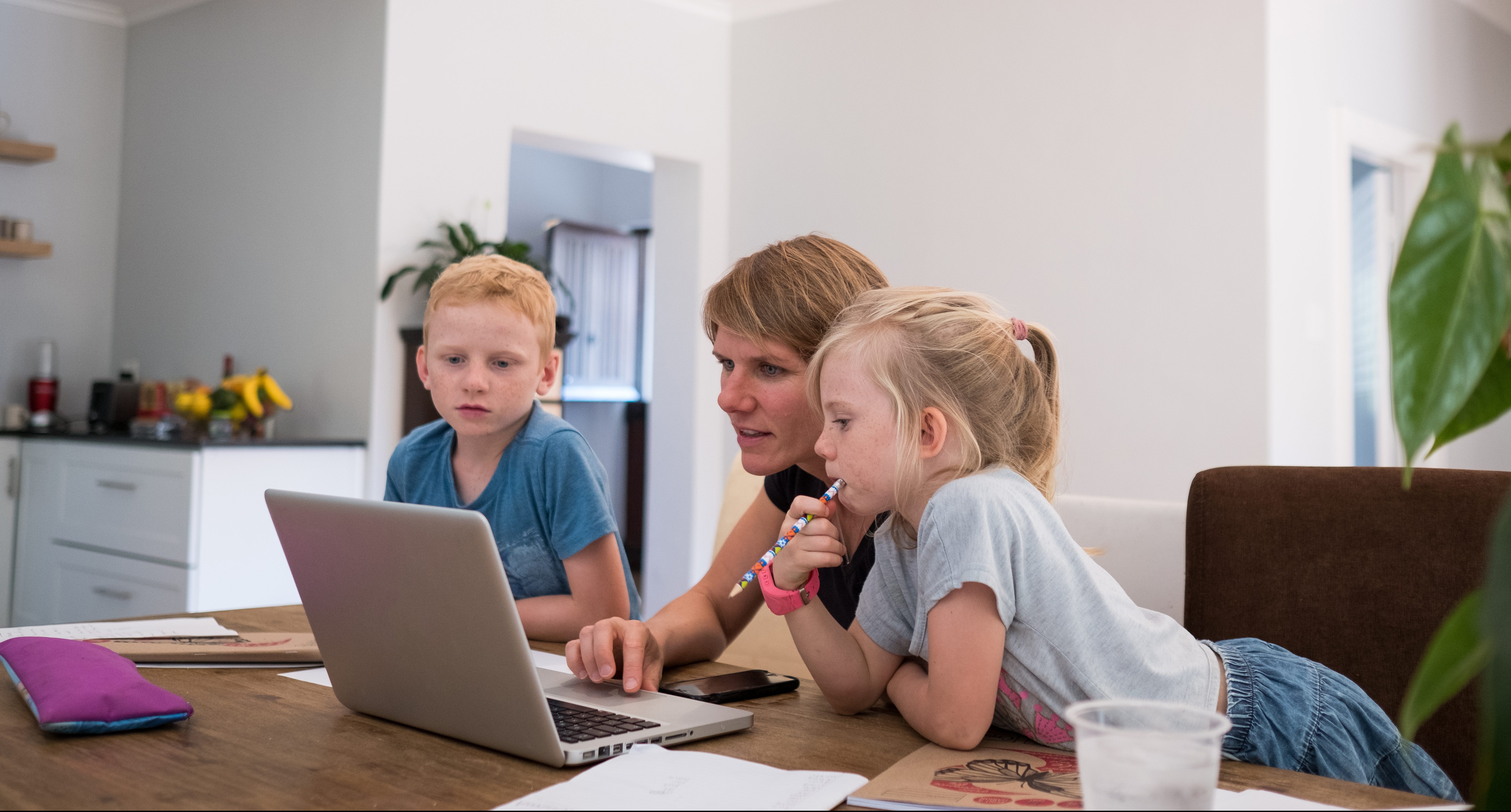 Homeschooling: Zwei Kinder lernen vor dem Computer mit ihrer Mutter
