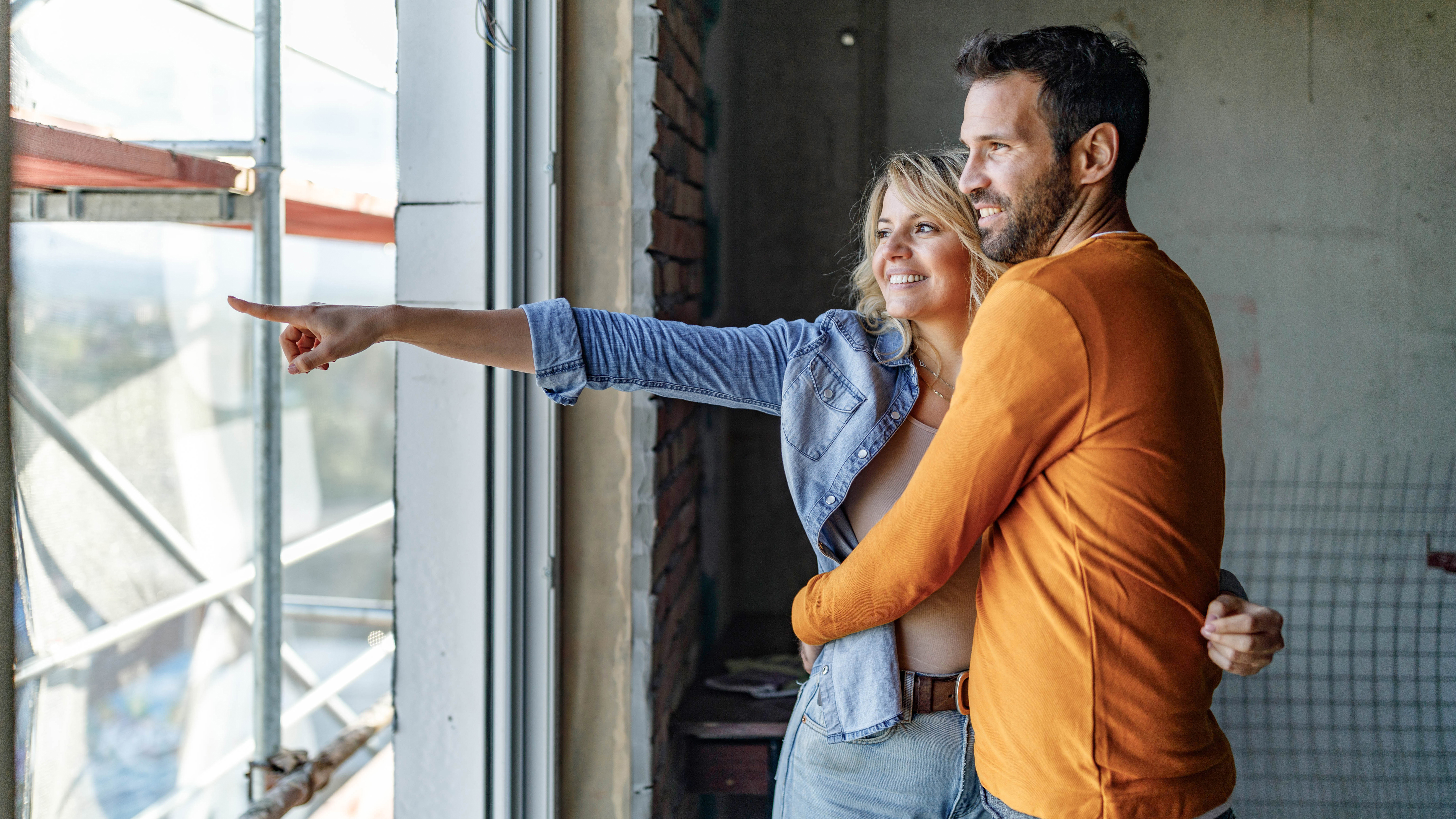 Paar steht am Fenster in unfertiger Wohnung