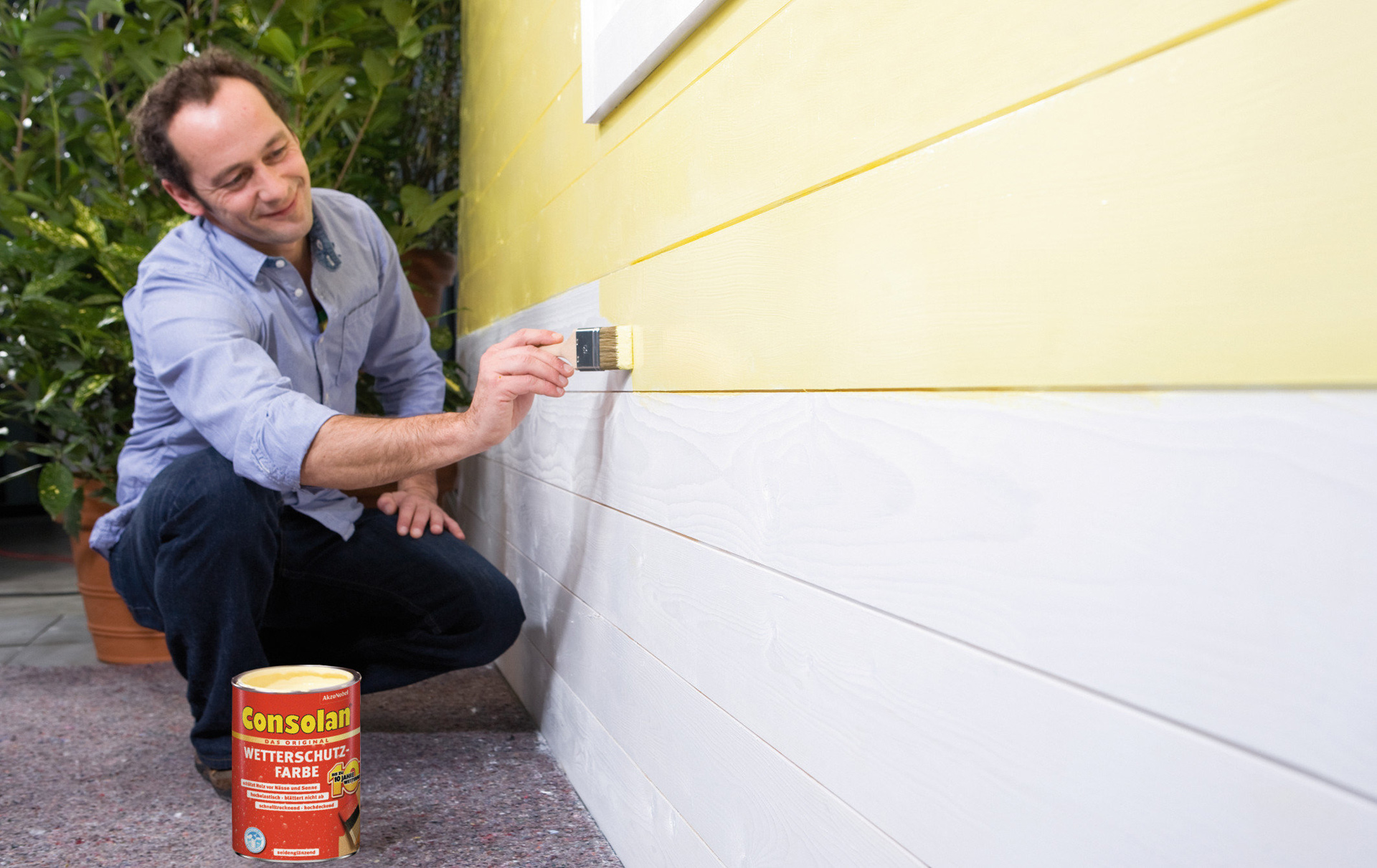 Holzwand eines Hauses wird mit Consolan-Wetterschutzfarbe gestrichen