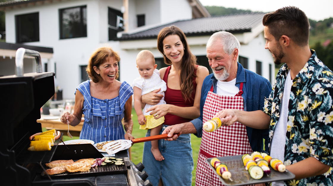 Drei Generationen im Garten eines Hauses beim Grillen