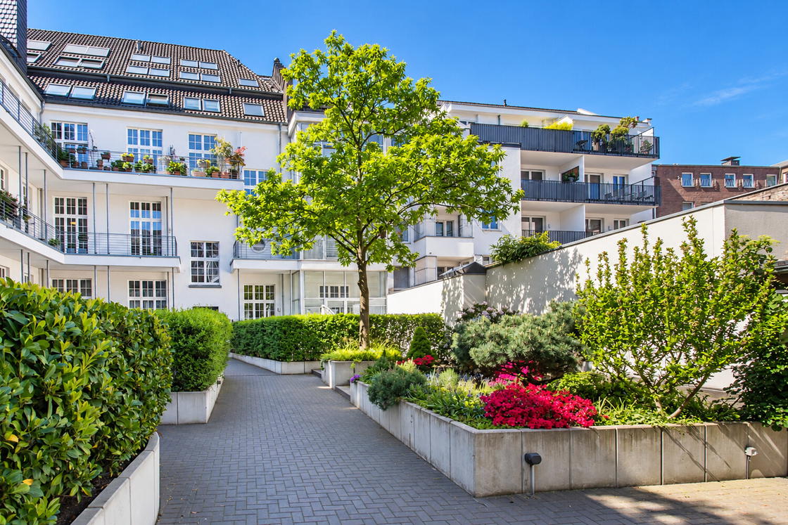 Sonniger Innenhof mit blühendem Garten