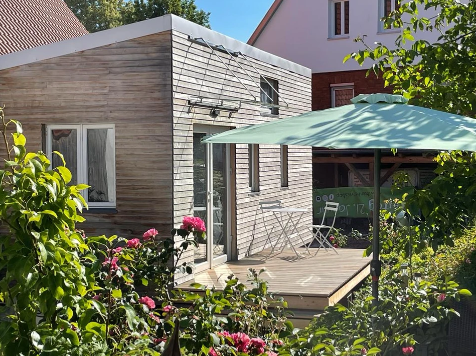 Das Tiny House Friedlinde steht in einem schön bewachsenen Garten.