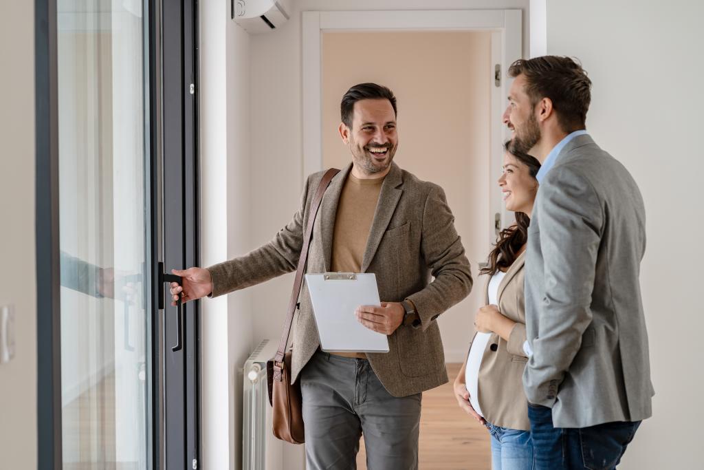 Immobilienmakler zeigt Paar eine Wohnung