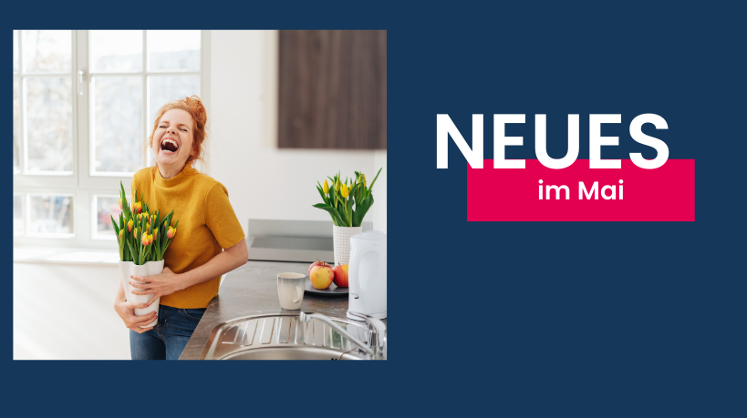 Junge Frau lacht auf, während sie eine Vase mit gelben Frühlingstulpen in einer sauberen, hellen Küche hält.