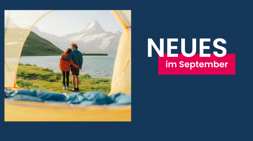 Rückenansicht eines sich umarmenden Paares, das an einem See zeltet und auf die hinter dem See liegenden Berge blickt. 