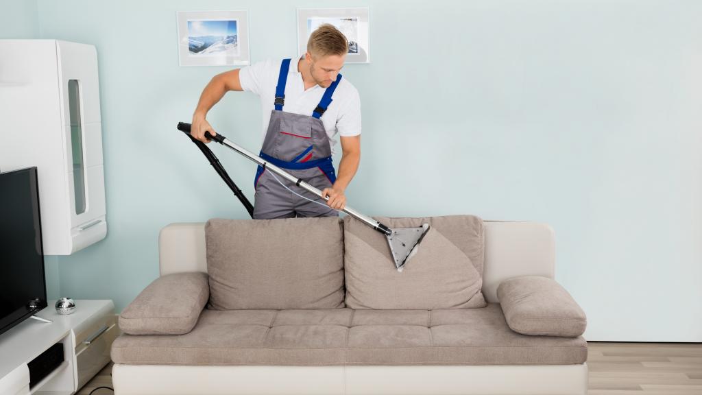 Mann reinigt Sofa