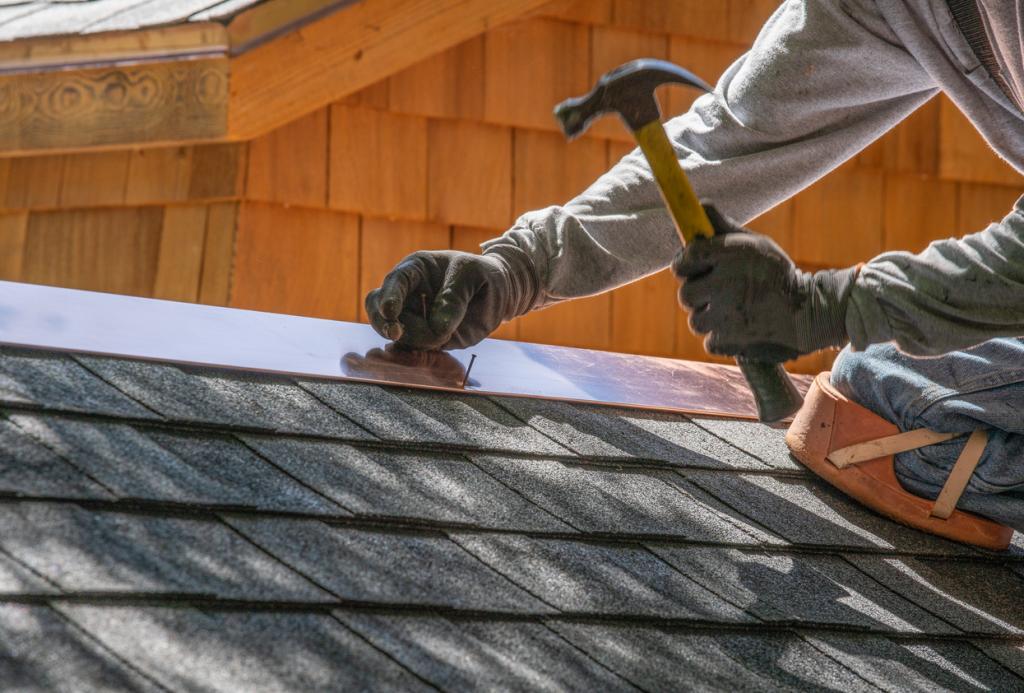 Handwerker arbeitet mit Hammer auf Dach