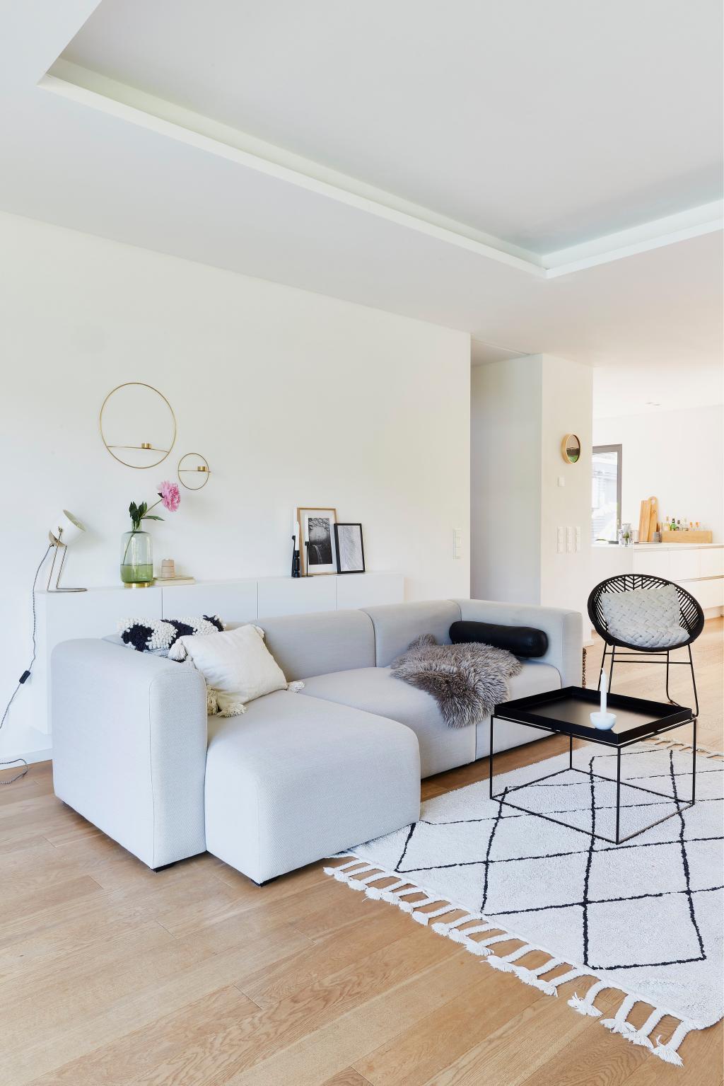Modernes, offenes Wohnzimmer mit grauem Sofa.