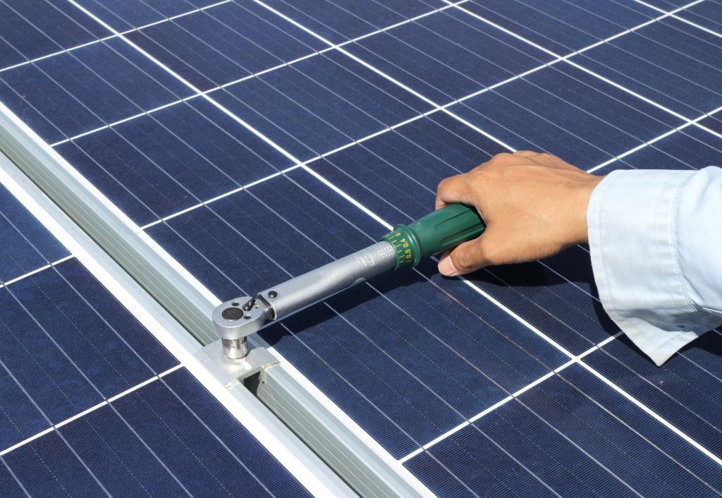 PV-Anlage: Mann befestigt Solarpanel an Unterkonstruktion