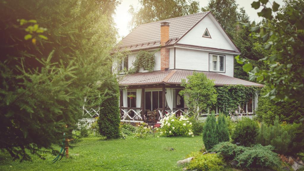 Ein schönes Landhaus im grünen Garten an einem sonnigen Tag.