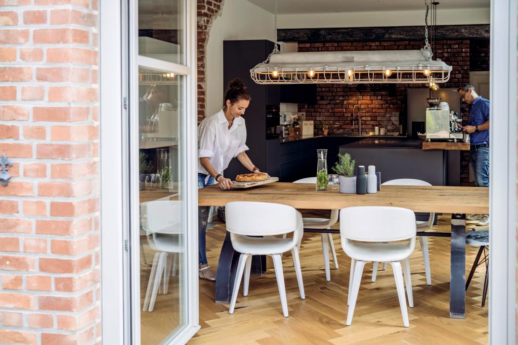 Ehepaar bereitet Kaffeetafel in einem Einfamilienhaus vor.