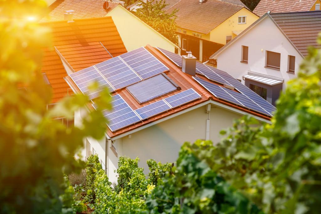 Photovoltaik-Paneele auf Hausdach im Grünen