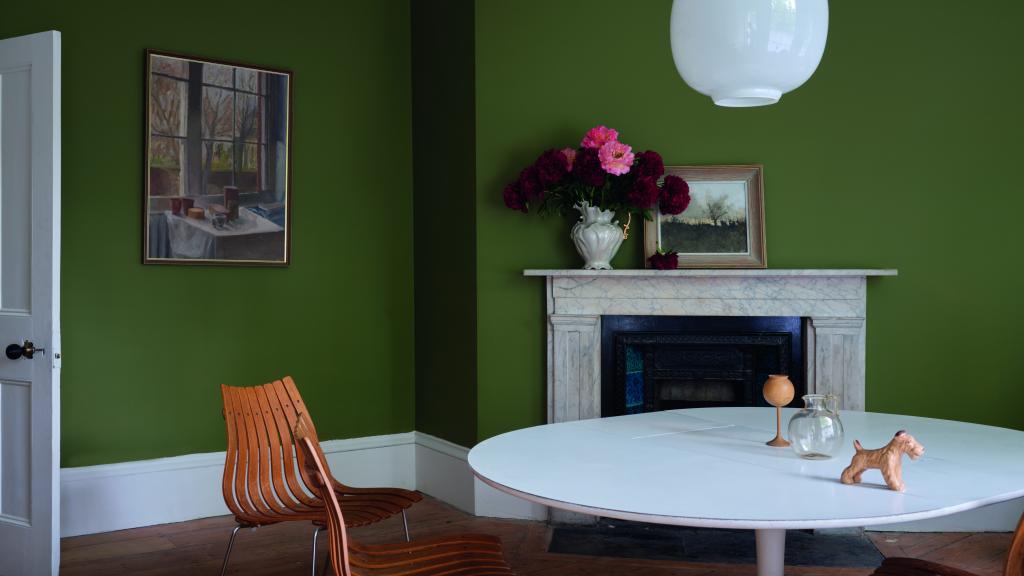Esszimmer mit Kamin, Esstisch und grüner Wandfarbe