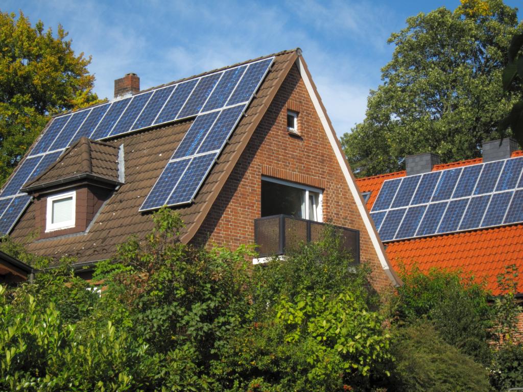 Älteres Haus mit Photovoltaik-Modulen auf dem Dach.