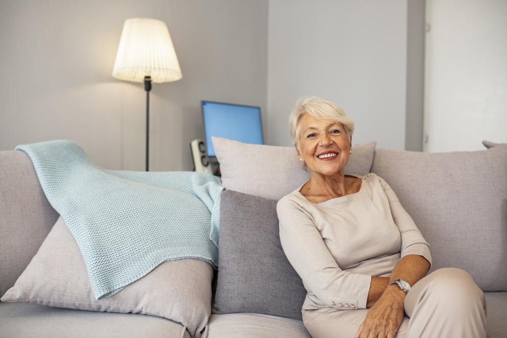 ältere Frau allein auf einem Sofa sitzend