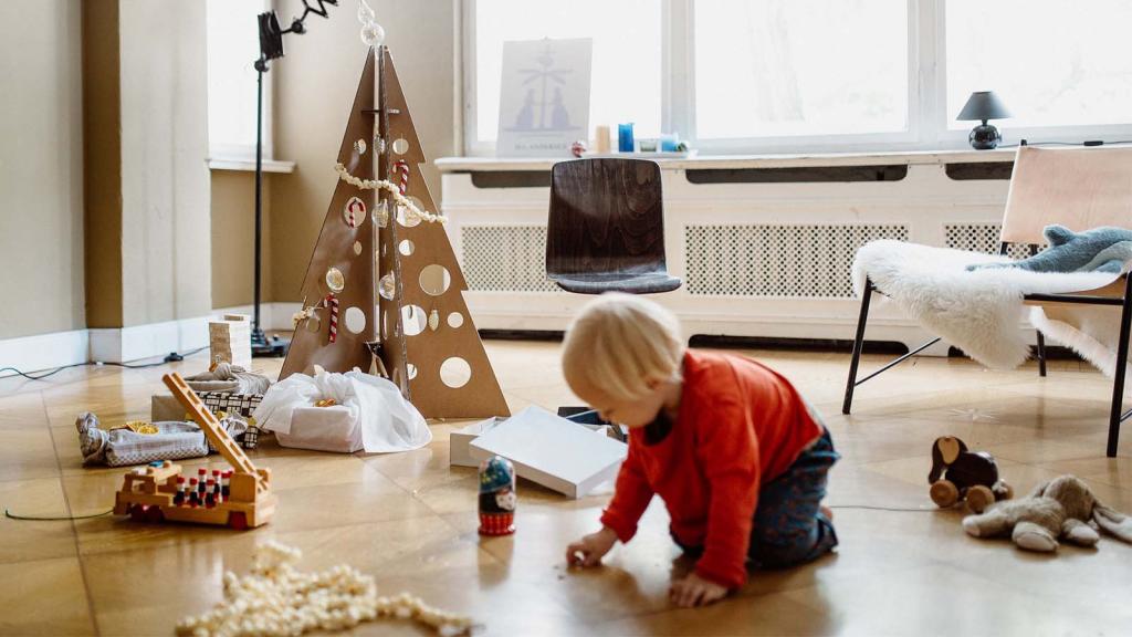 Kind spielt vor Weihnachtsbaum aus Pappe von room in a box