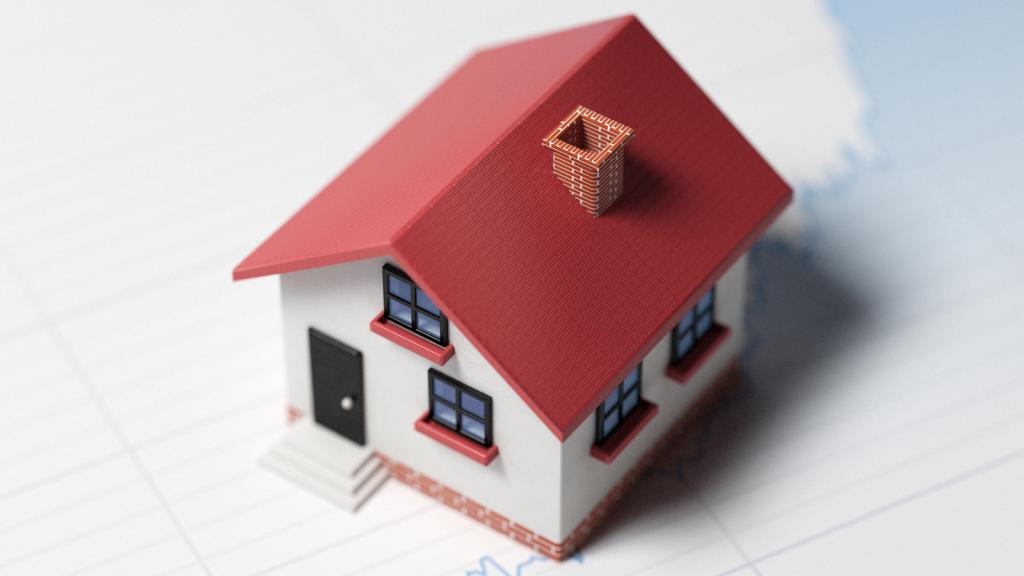 Günstige Bauzinsen: Kleines Modellhaus steht auf einer Zinsgrafik.