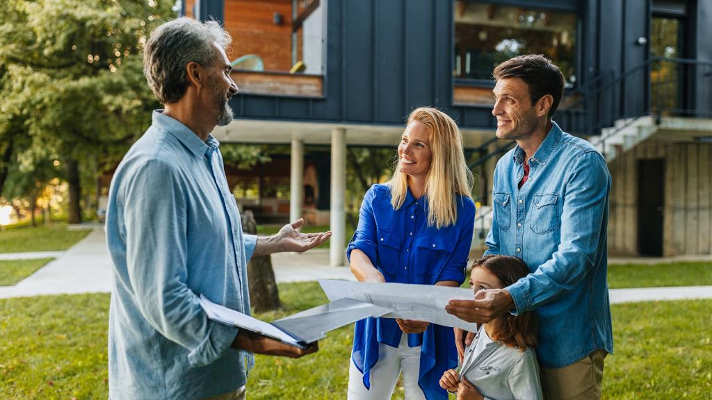Makler mit Familie vor Haus