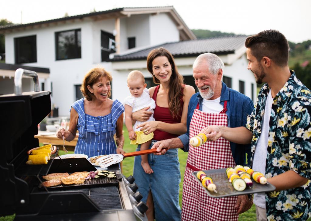 Drei Generationen im Garten eines Hauses beim Grillen