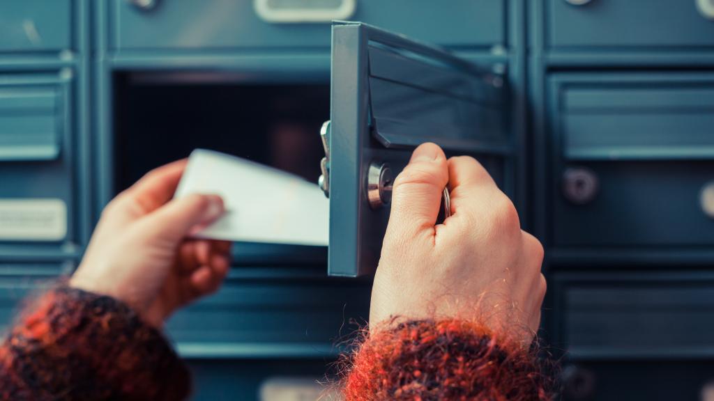 Hand holt Briefe aus Briefkasten