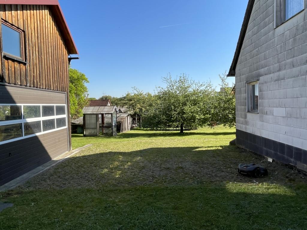 Blick zwischen Haus und Halle mit der  PV Anlage