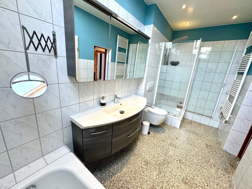Tageslichtbad mit Wanne und Regendusche im Erdgeschoss