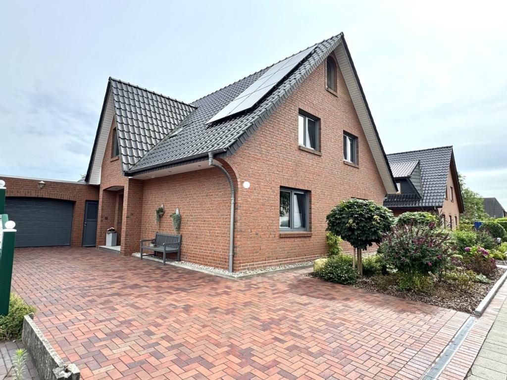 Seitliche Ansicht auf Haus, großzügige Stellplätze und liebevoll gestalteten Vorgarten