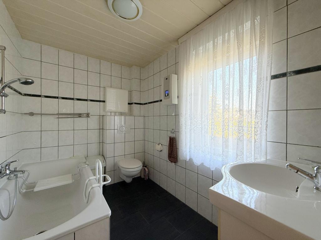 Badezimmer mit Badewanne und Dusche