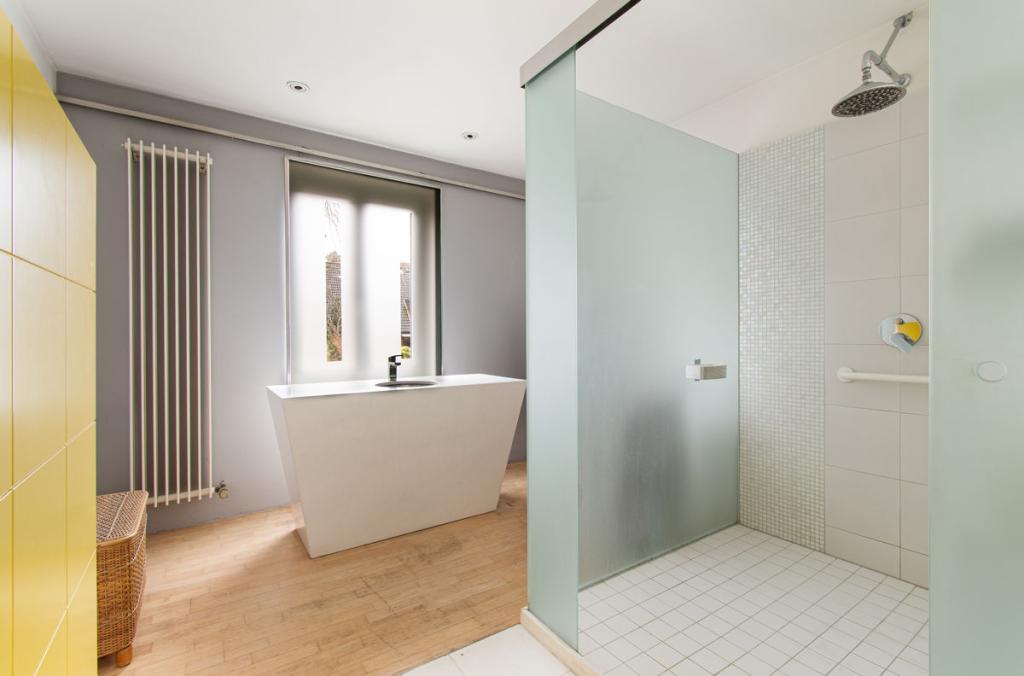 Badezimmer mit großer Dusche und freistehendem Waschtisch
