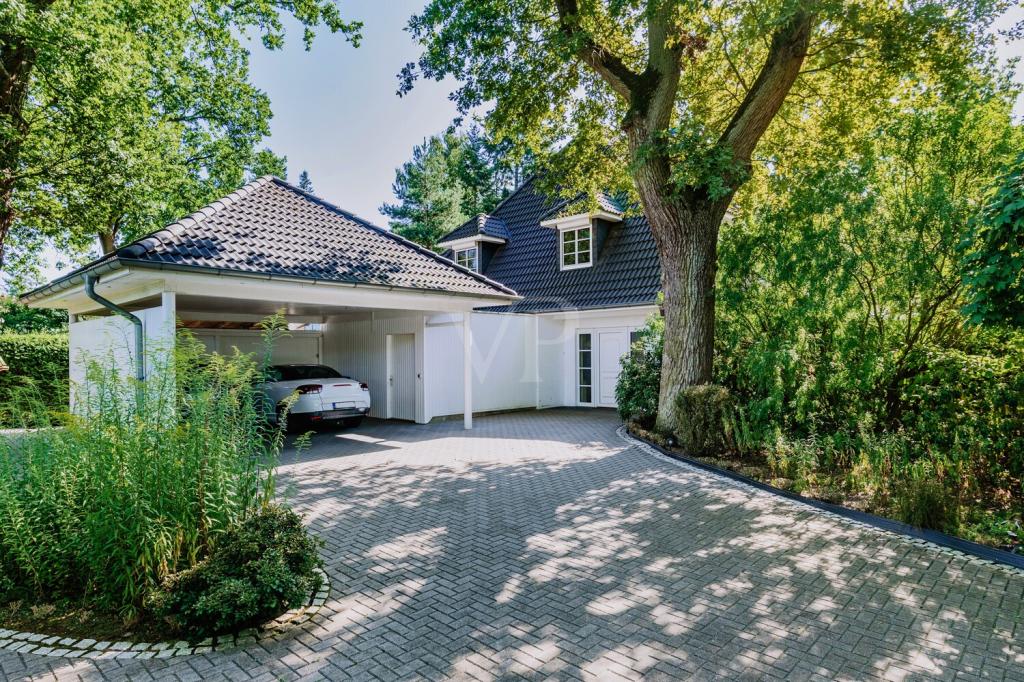 Großzügige Hofeinfahrt mit Blick auf den Doppelcarport und Zugang zur Haustür auf der Nordseite.