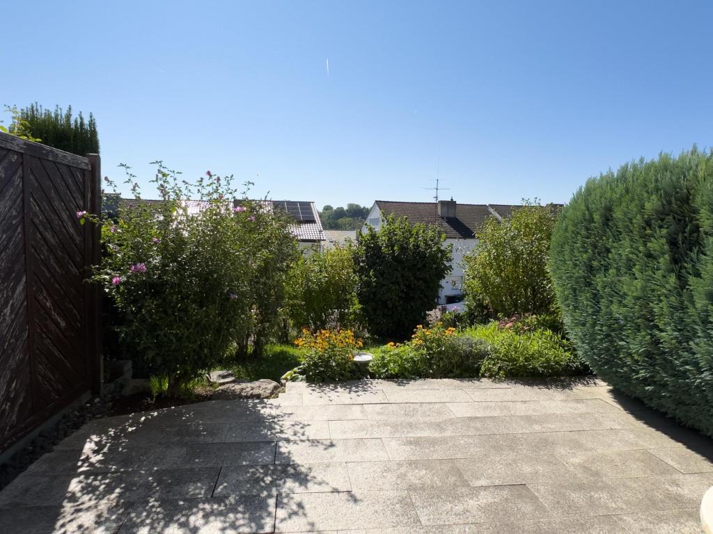 sonnige Terrasse mit Garten