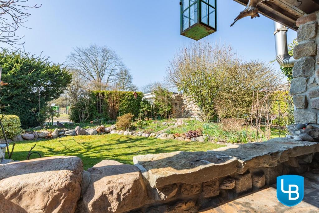 Blick über die Steinmauer in den Garten