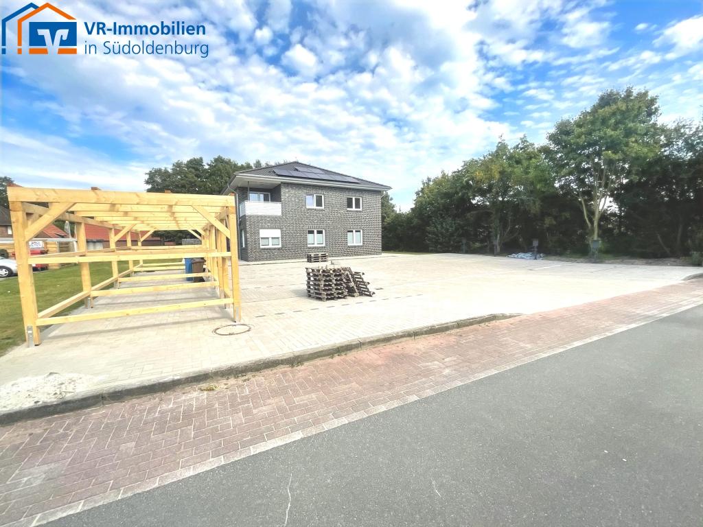 Parkplatz mit Wallboxen und separaten Abstellräumen für Fahrräder und Mülltonnen