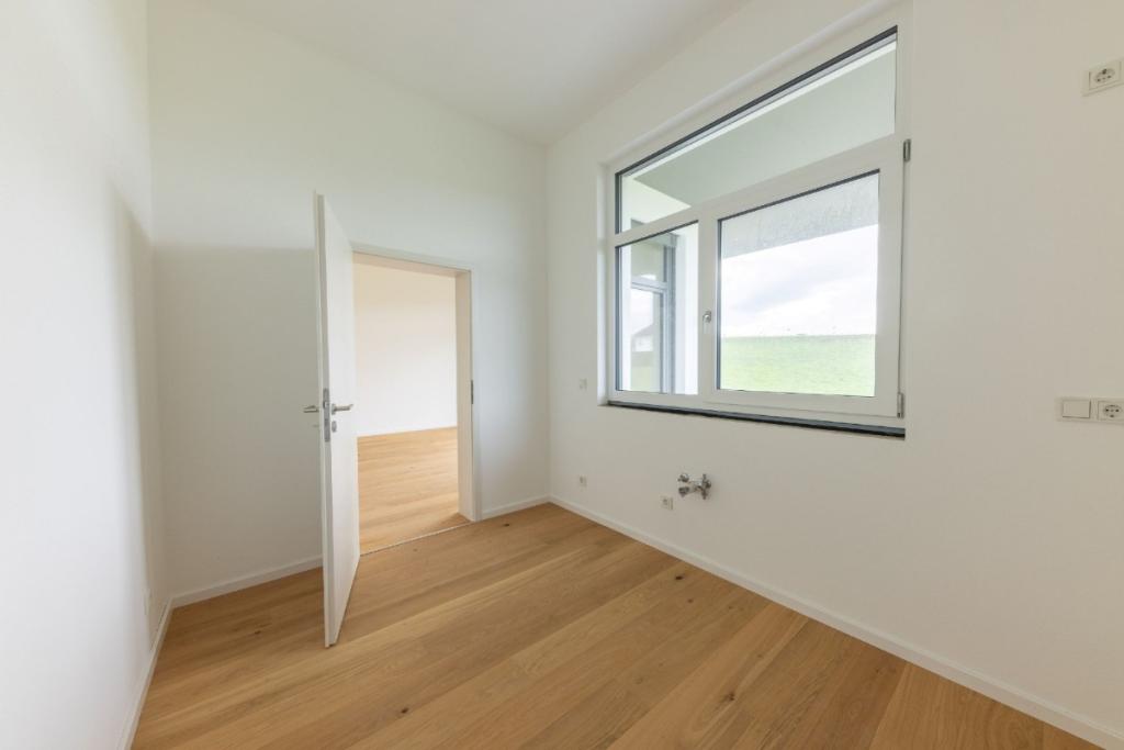 Küche mit Blick nach draußen und Blick durch die Türe ins Wohnzimmer