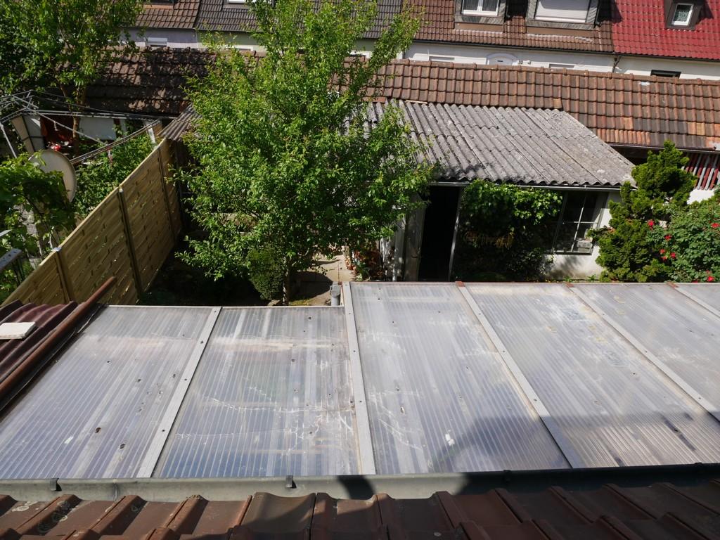 Blick über das Wintergartendach auf Garten und Garage