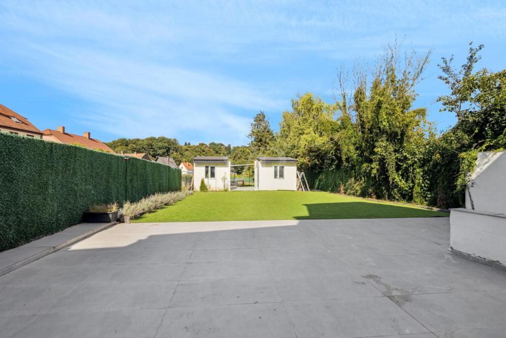Terrasse mit Blick auf Garten mit Außenküche und Gartenhäuser