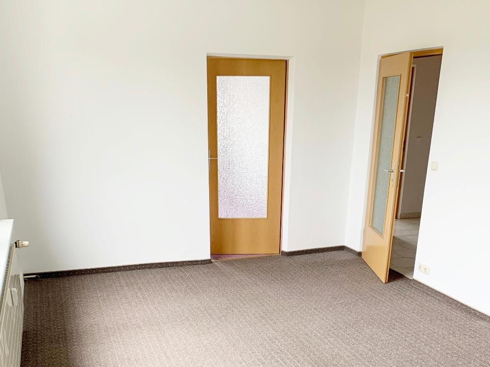 Wohnzimmer mit Blick Richtung Schlafzimmer und Flurbereich