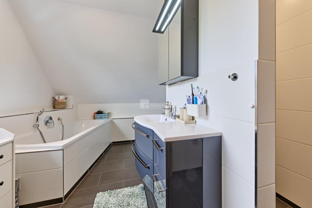 Im Badezimmer mit Dusche, Wanne und Fenster