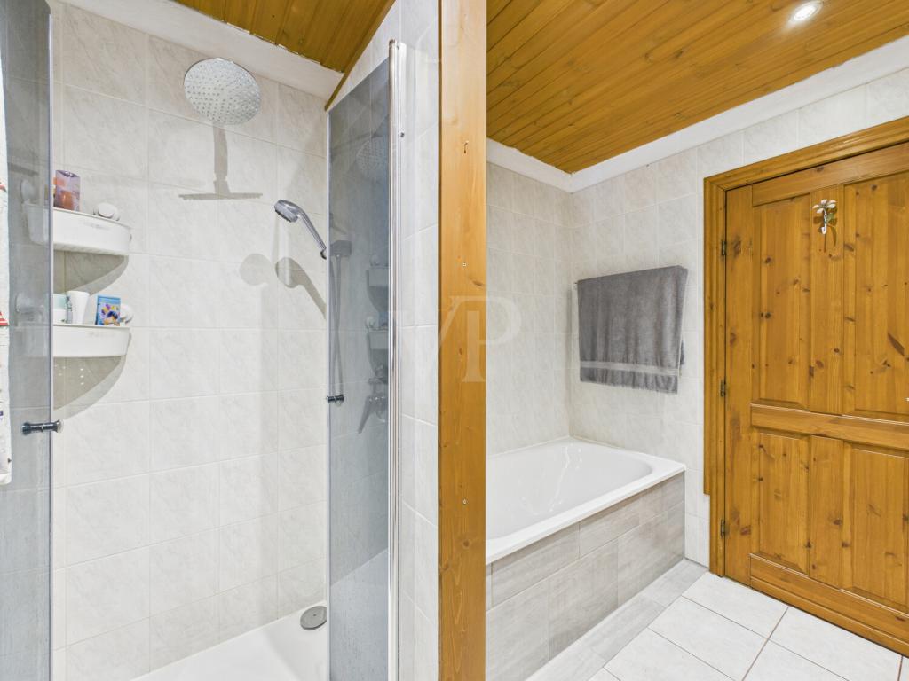 Badezimmer mit Badewanne, ebenerdiger Dusche, Waschtisch, WC und Fenster 