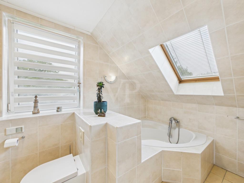Badezimmer mit Eckbadewanne im Dachgeschoss