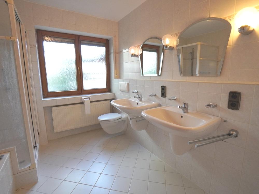 Badezimmer mit Doppelwaschbecken, Badewanne, Dusche und WC
