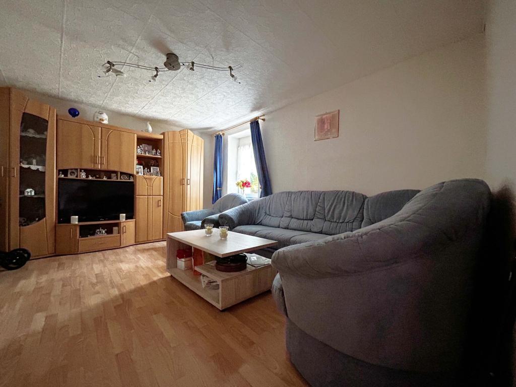 Wohnung 2 Wohnzimmer: Weiche Formen und warme Töne – ein Raum zum Zurücklehnen