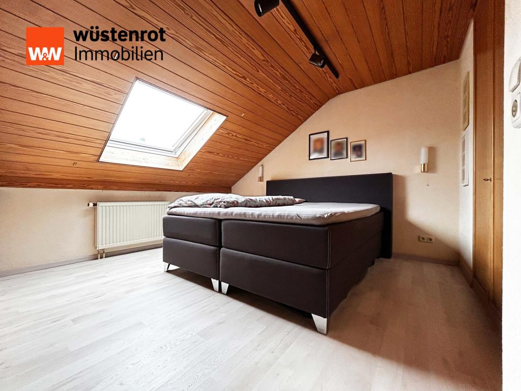 OG Schlafzimmer 2: Weiches Licht fällt durch das Dachfenster – ein stiller Ort zum Ausruhen und Träumen