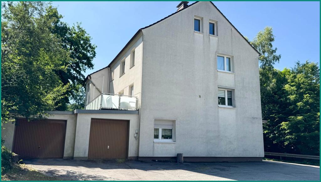 Gebäudeansicht mit Garagen links